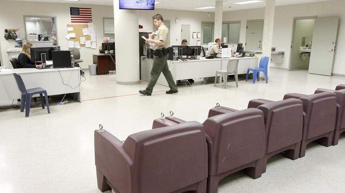 File -- A Benton County corrections officer walks through the booking area at the Benton County jail in Kennewick.