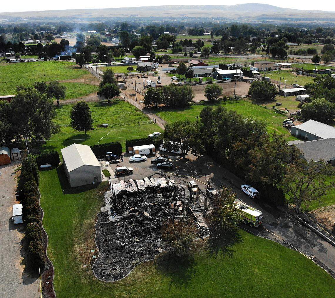 A house along East Finley Road just east of South Locust Lane smolders Wednesday afternoon as officers investigate the shooting death of one man and the wounding of another.
