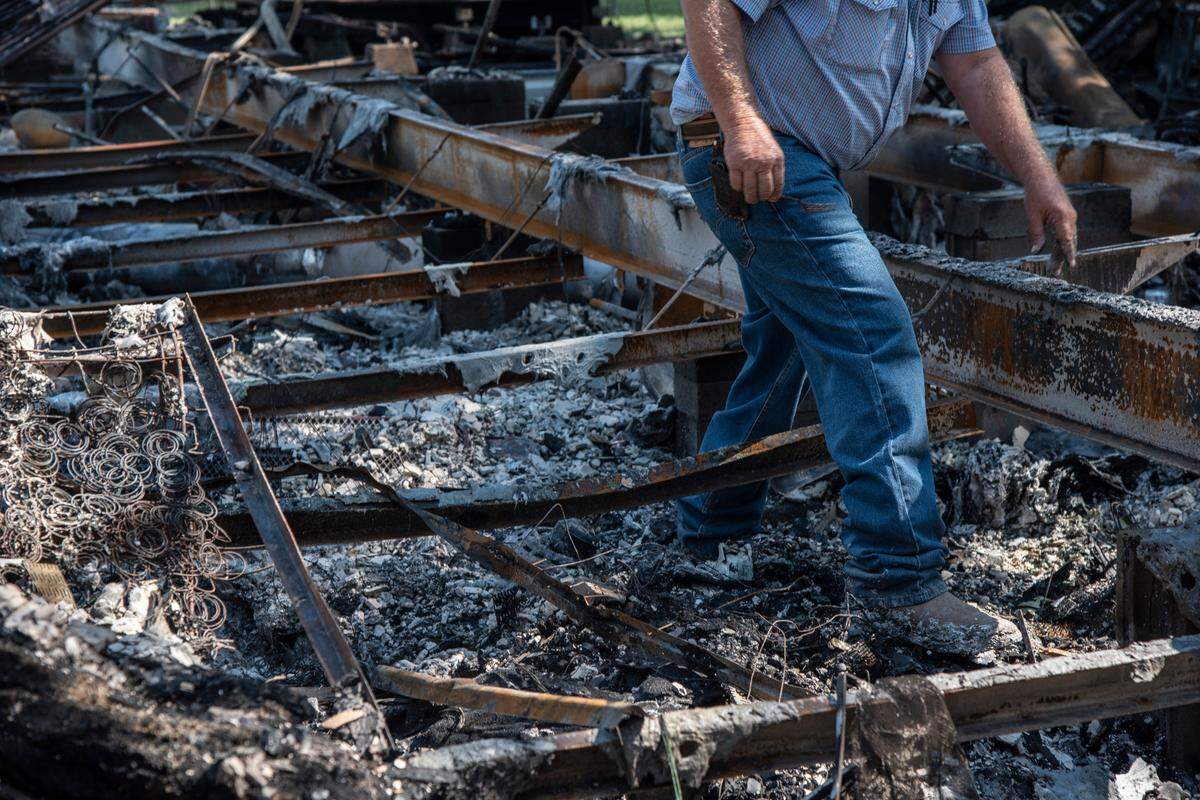 Dairy farmers Lavonne and Jim Boogerd sift through the charred remains of their home which burned down during a fire that burned nearly 800 acres in Prosser on Labor Day.