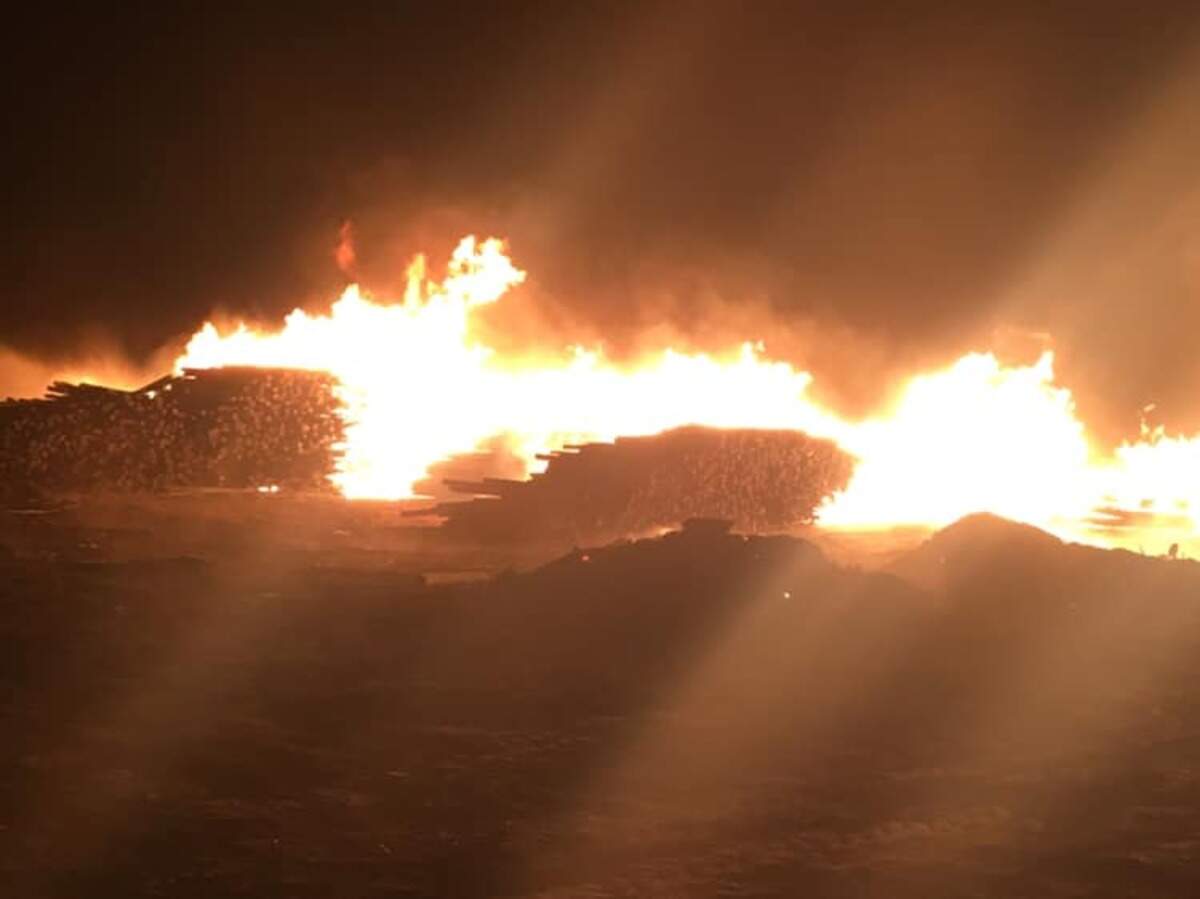 An agricultural burn rekindled near the intersection of Hanks and Case roads and spread to several large stacks of hops poles.