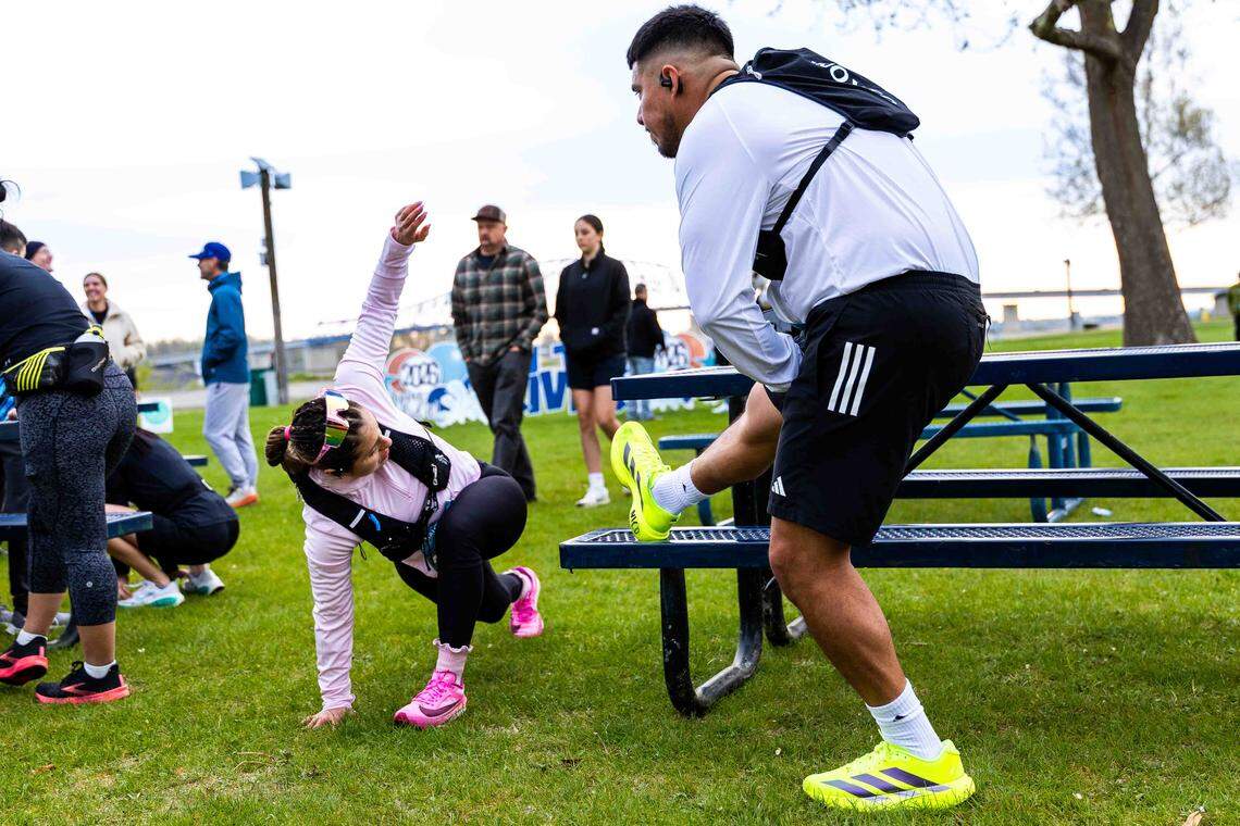 Lucero and Adolfo Garza of Yakima stretch before the Run the River Marathon Saturday, April 18, 2026, at Columbia Park in Kennewick. The pair competed in their first marathon after training together for the 26.2-mile race.