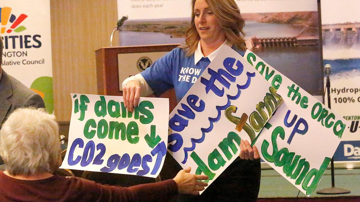 Stephanie Barnard hands out signs at a rally in support of the lower Snake River dams in 2020. Barnard is campaigning for the Washington state Legislature to represent District 8.