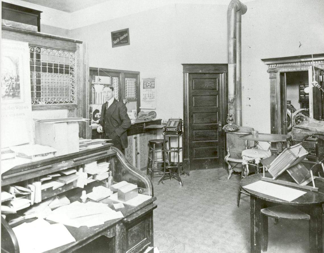 The interior of the White Bluffs Bank is shown in a photo that likely dates to the early 1920s. A teller stands behind the counter as the door to the banks vault, far right, is left open for the photograph.