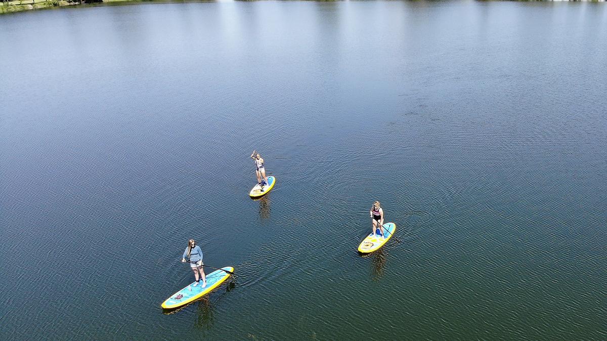 Instructor Krista Patterson of Northwest Paddleboarding leads a private session for Karla Verbarendse, upper left, and Denise Howard, lower right, Thursday morning at Two River Park in Finley. The two women are in town visiting family and found a perfect way to stay cool on a hot summer day. They said they had both enjoyed previous lessons from Patterson and sought her out for another excursion.