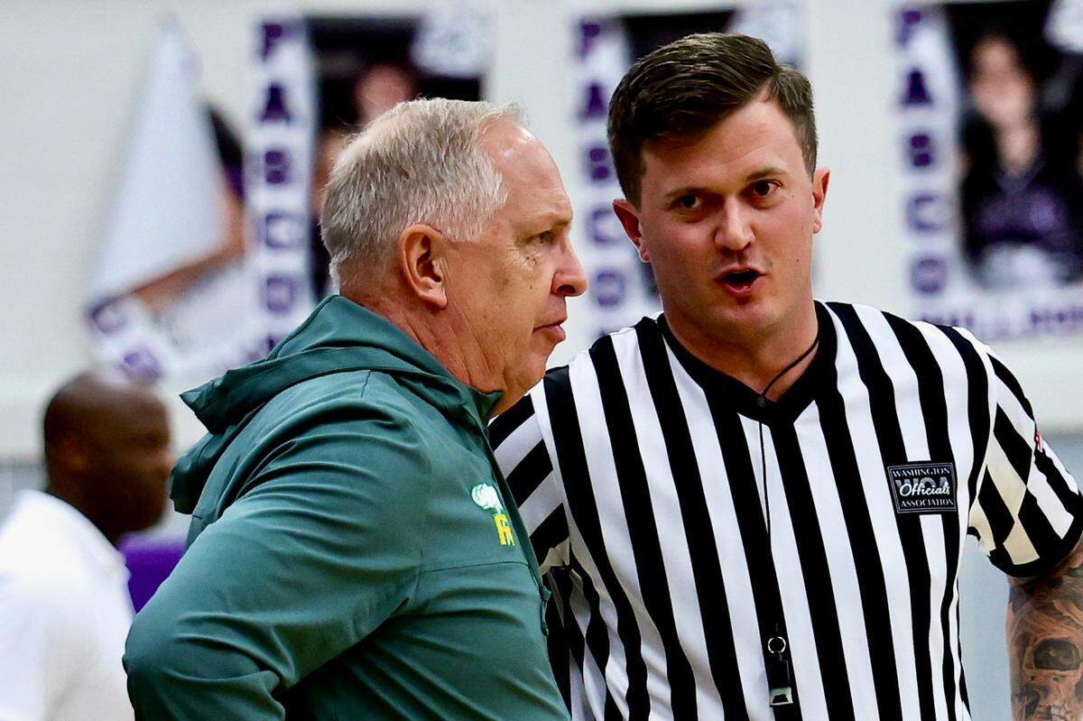 Richland basketball head coach Earl Streufert speaks with a referee.