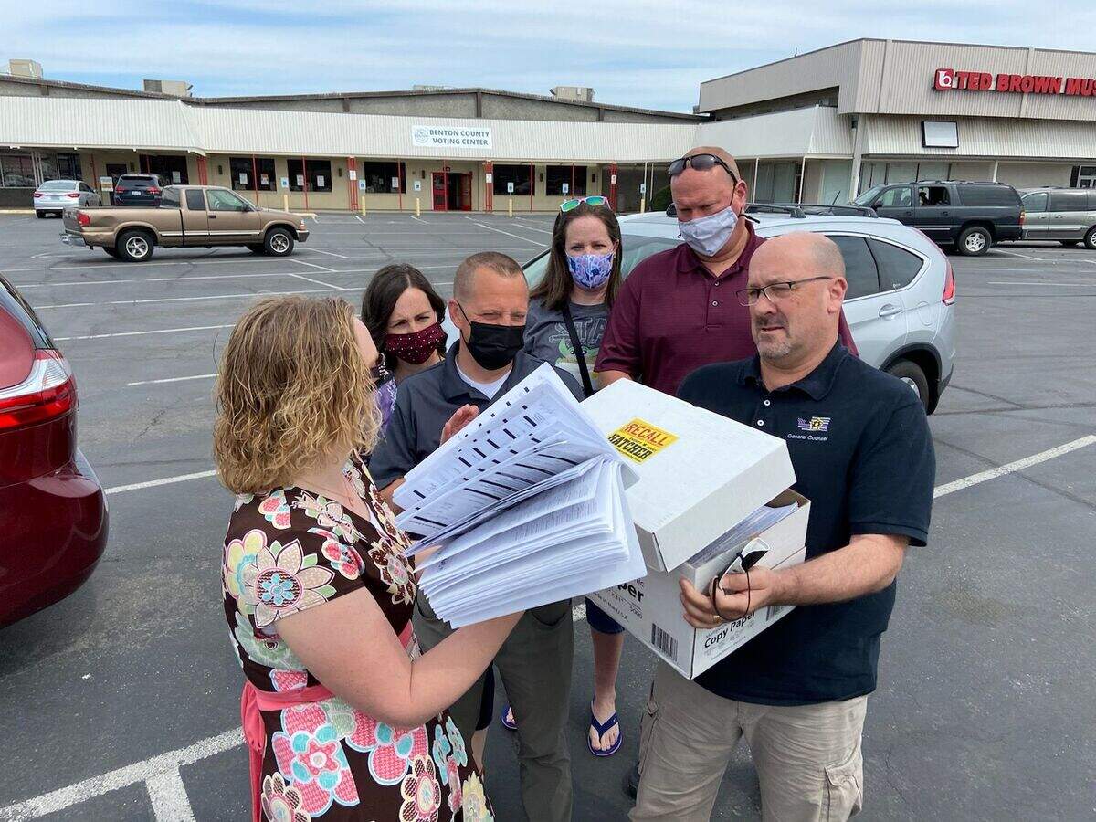 Kathlen Wierschke of West Richland, left, and sheriff guild’s lawyer Alan Harvey of Vancouver get ready to submit the petitions for a ballot measure on recalling Benton County Sheriff Jerry Hatcher from office.