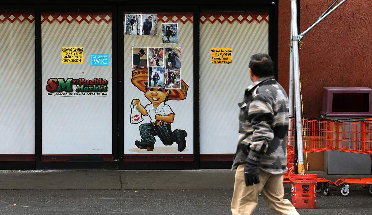 A man walks past the entry doors for the SuperMex El Pueblo Market grocery store Monday morning on North 20th Avenue in Pasco.