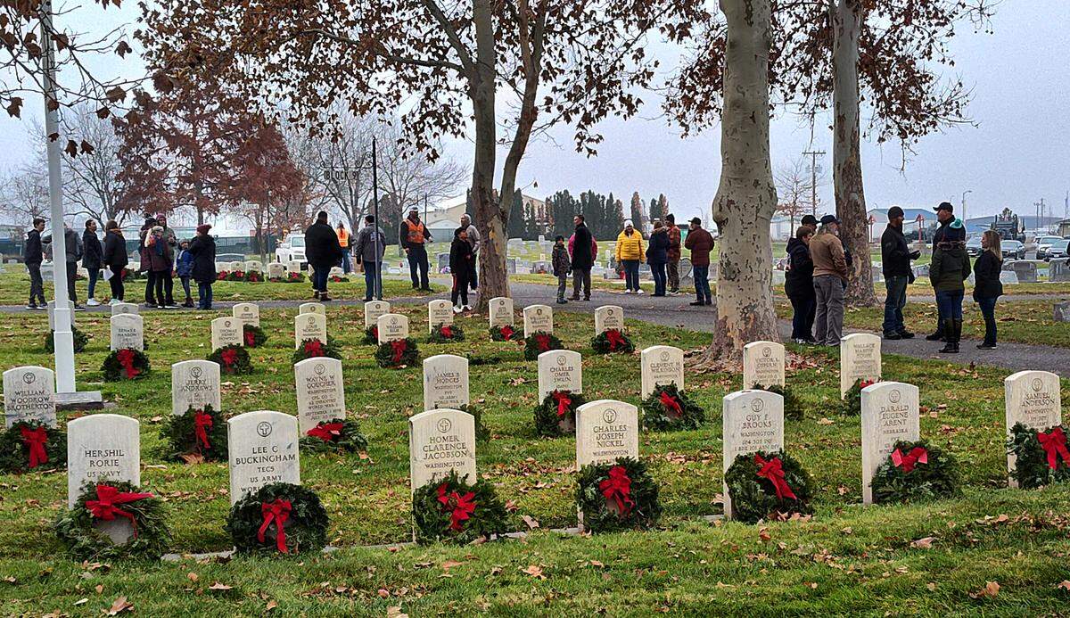 Community members stand in Pasco’s City View Cemetery after placing wreaths on the graves of veterans for the holiday season for the Wreaths Across America event in 2023.