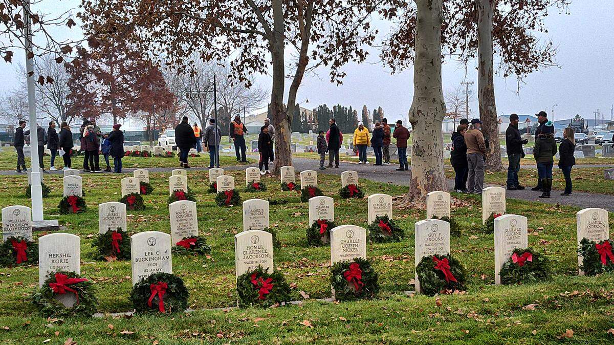 Community members stood in Pasco’s City View Cemetery after placing wreaths on the graves of veterans for the holiday season during the Wreaths Across America event in December 2023.