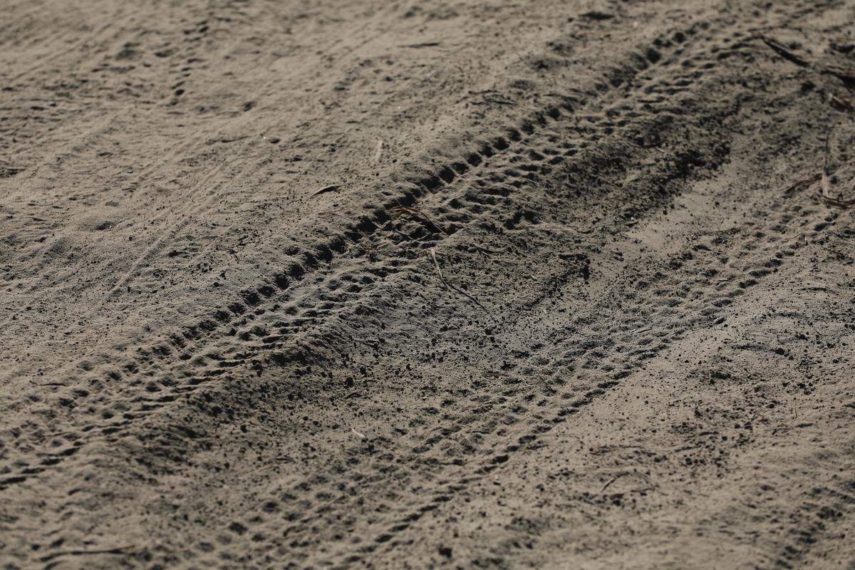 Mountain bike tire tracks left in the soft dirt on a trail on empty desert landscape south of Kennewick near the Washington State Patrol office.