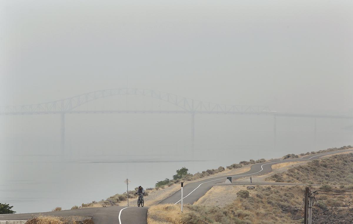 A bicyclist makes his way along the paved pathway between the cable and blue bridges Monday morning on the Pasco side of the Columbia River shore. The National Weather Service reported that visibility in Pasco on Monday afternoon was just 1.25 miles but in Richland it was 4 miles.