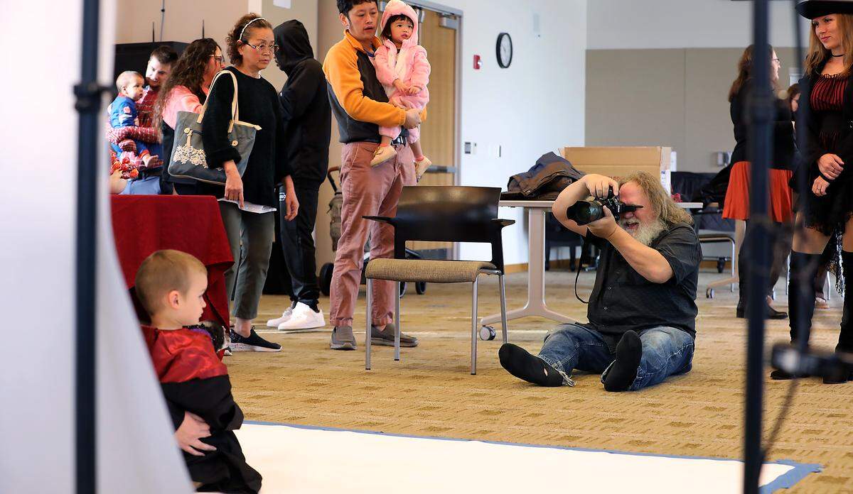 People wait in line as photographer Scott Butner takes free portraits of residents in their Halloween costumes Friday morning at the Richland Public Library. It's a tradition he's done for 16 years.