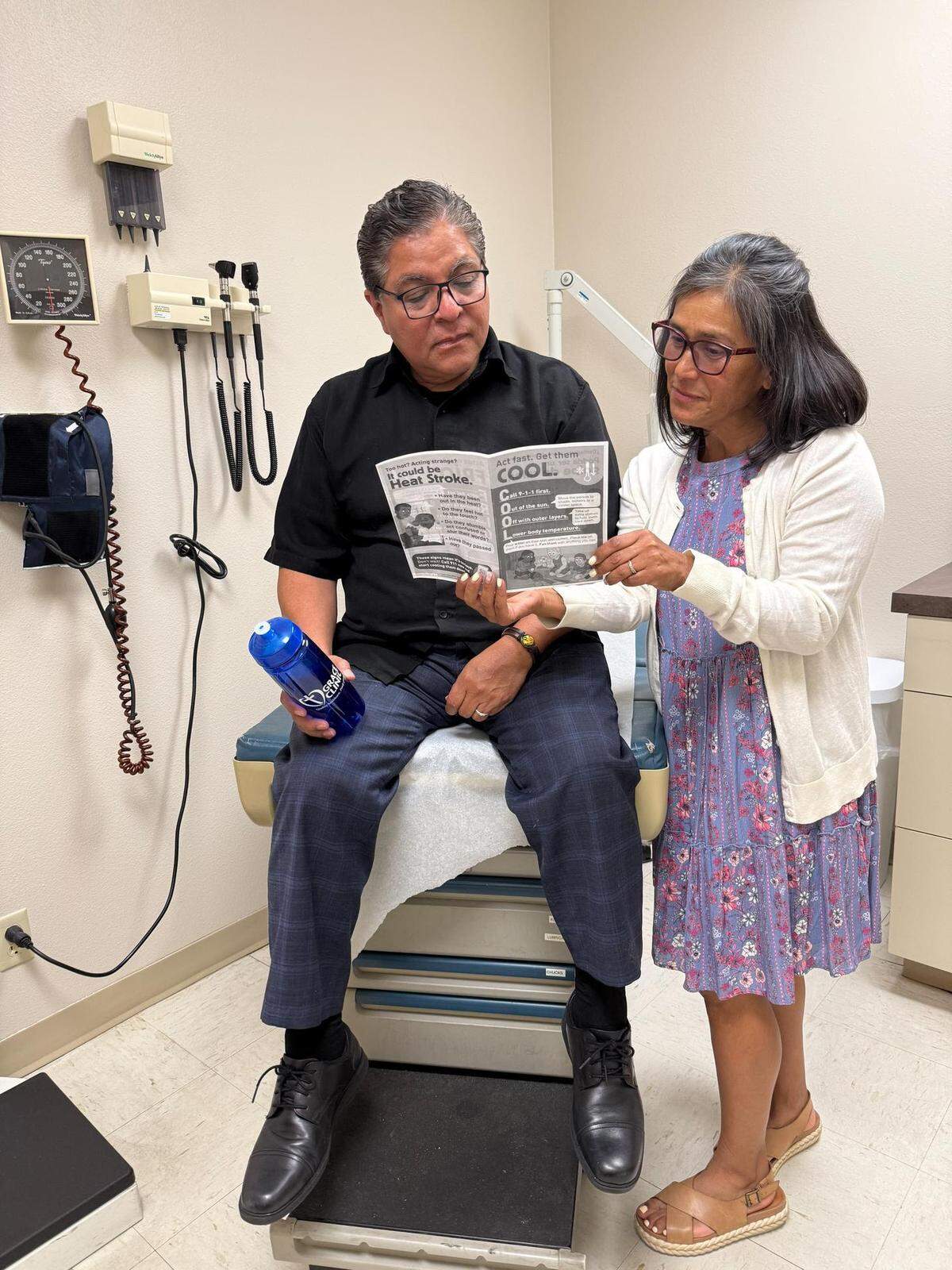 The community outreach coordinator for Grace Clinic, Ericka Watson, shares heat education materials from Americares, plus a water bottle purchased with funding from Americares, with a patient at Grace Clinic in Kennewick, Wash., this month.