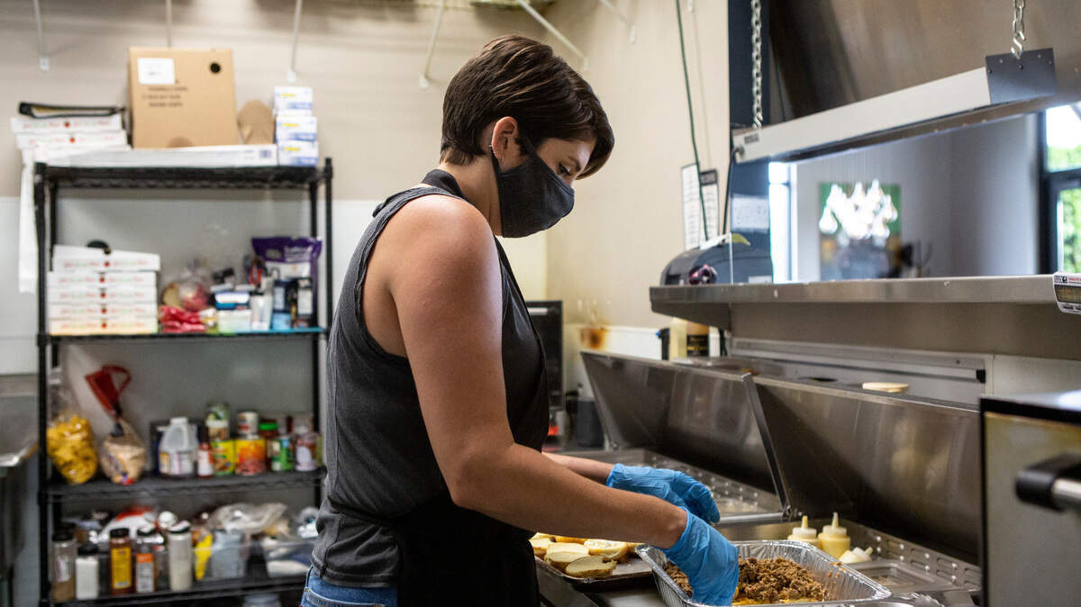 Restaurants and bars remain the most hard-hit in the Tri-Cities. Tap & Barrel owners Kendra Sadler works to fill a customer order recently.