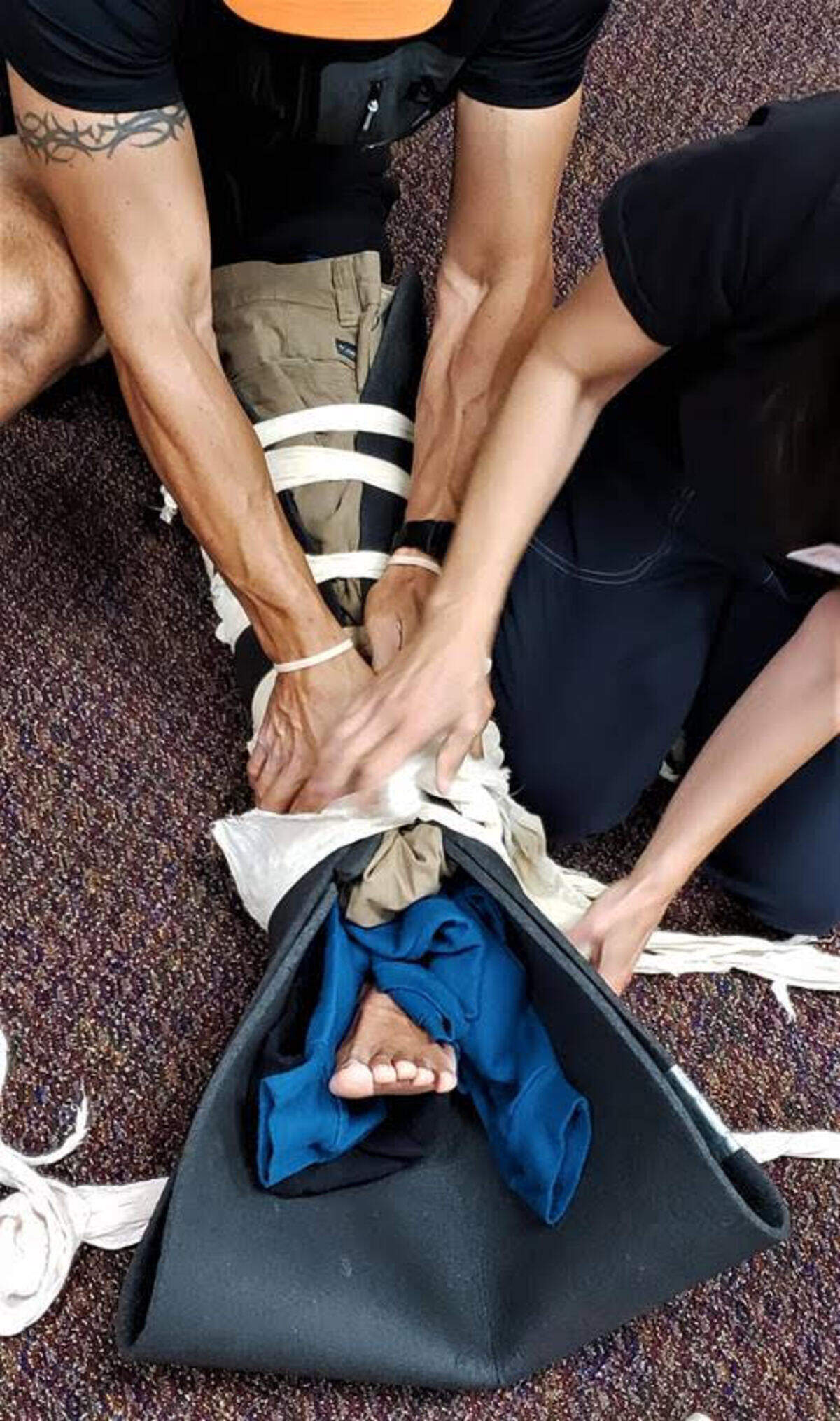 Participants in the Wilderness First Aid course at the Tri-City Court Club practice splinting a broken leg with items from their day packs.