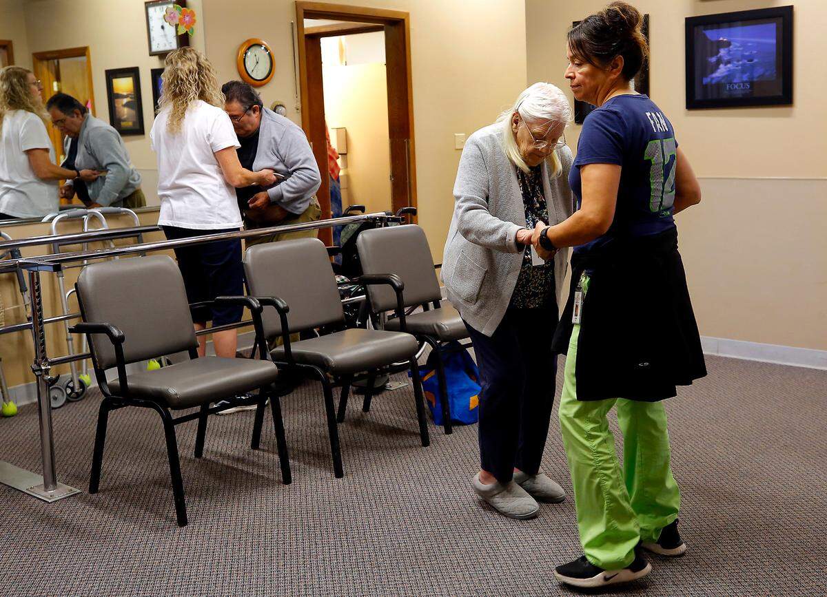 Aides Ann Markham, left, and Anna Borjas help clients the Adult Day Services of the Tri-Cities facility work on their physical therapy regimens recently at the downtown Kennewick facility.
