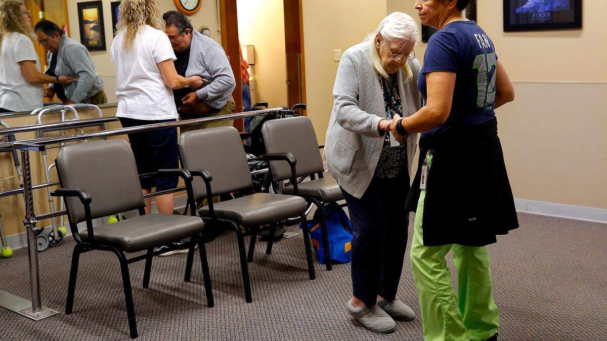 Aides Ann Markham, left, and Anna Borjas help clients the Adult Day Services of the Tri-Cities facility work on their physical therapy regimens recently at the downtown Kennewick facility.