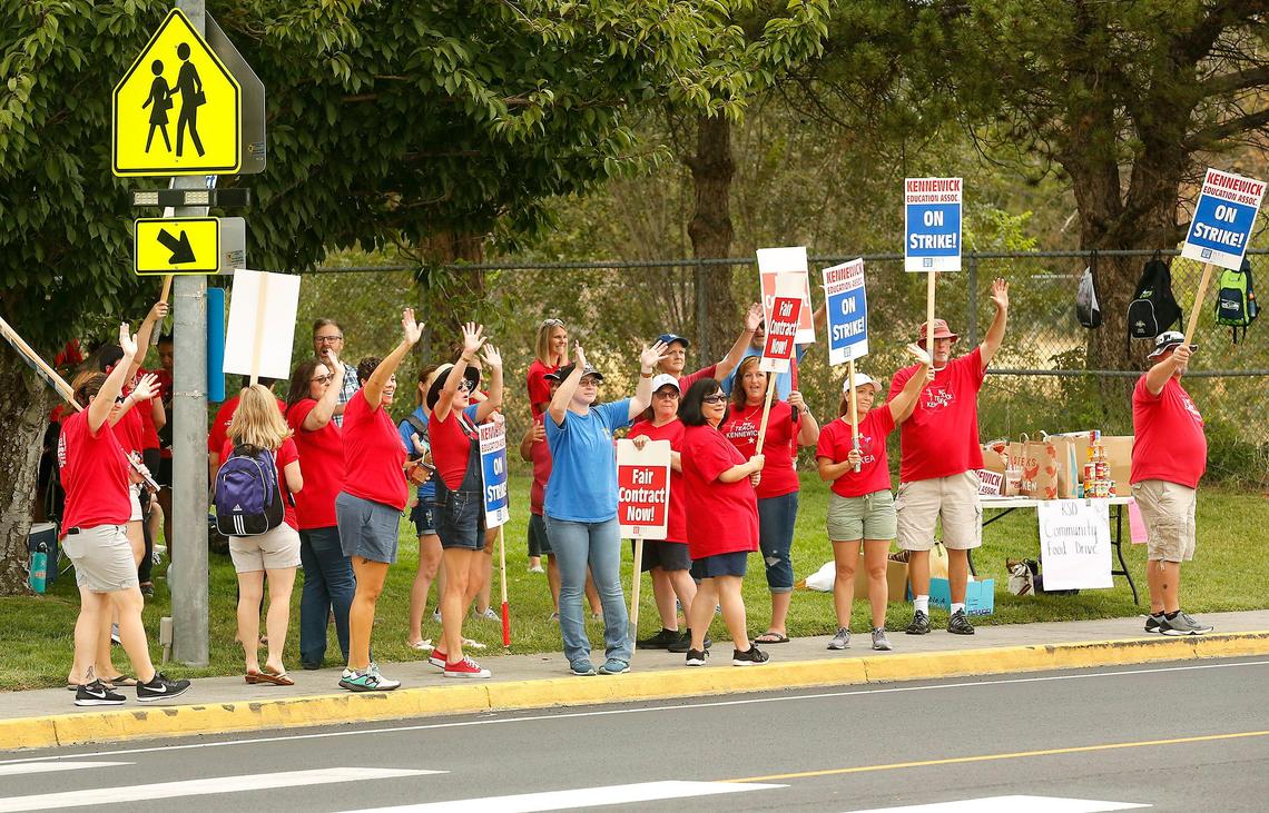 Striking Kennewick teachers and supporters wave to a honking motorist Thursday morning while picketing across the street from Park Middle School on West 10th Avenue in Kennewick. Watch a video: tricityherald.com/video