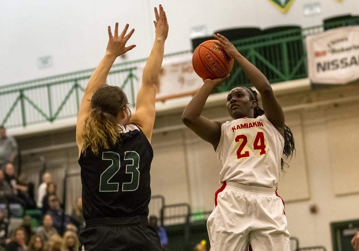 Peninsula’s Kara McKinney (23) guards Kamiakin’s Oumou Toure (24) as she shoots the ball during a 3A girls state regional game played at Richland High School on Saturday. Kamiakin defeated Peninsula 78-63.