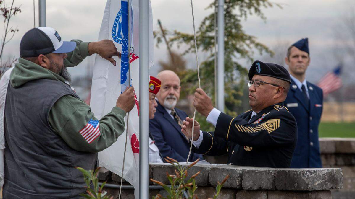 Volunteer Felipe Bautista assists Sergeant Major Walter Castilleja Jr. of the U.S. Army Reserves in the changing of the Army flag during a Veterans Day ceremony at the veteran memorial at City View Cemetery in Pasco in 2021.