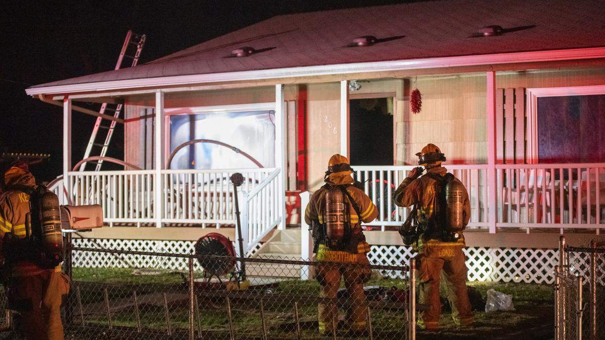 Firefighters work to extinguish a fire at a home on Quincy Street in Kennewick. The blaze left a man in critical condition.