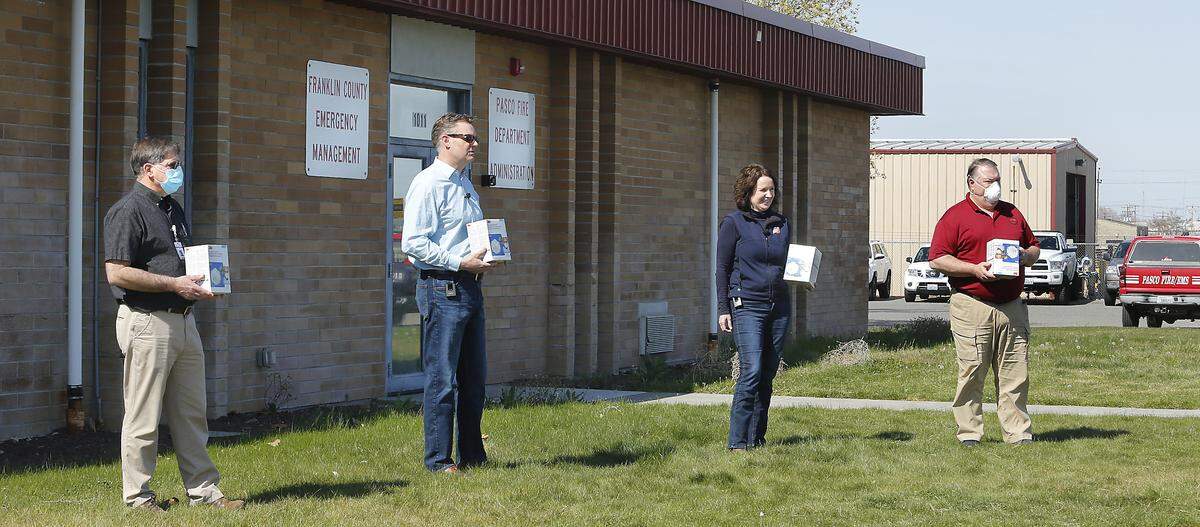 Rick Dawson of the Benton-Franklin Health District, TRIDEC president and CEO Karl Dye, Bechtel Principal Vice President Valerie McCain and Sean Davis director of Franklin County Emergency Management, from left, maintain proper social distance during a N95 mask donation by the Hanford contractor to Tri-Cities emergency responders and health care providers.