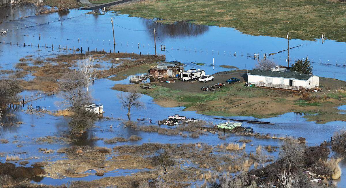Yakima River floodwaters surround several structures and numerous vehicles Friday morning on Hyde Road off Van Giesen Street in Richland.