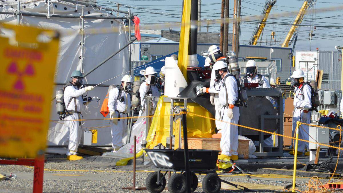 Workers are shown at one of the Hanford tank farms where 56 million gallons of radioactive waste are stored in underground tanks.