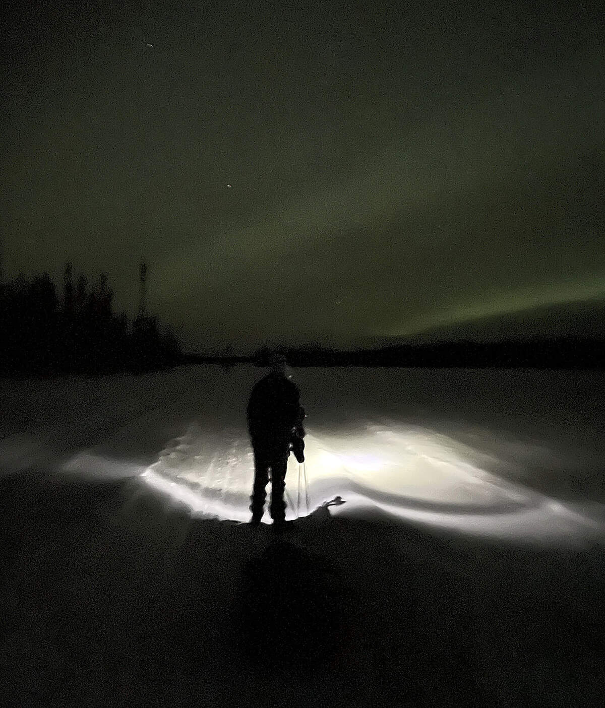 The Northern Lights show against the night sky as Brandon Lott navigates with a headlamp during this past February’s running of the Iditarod Trail Invitational in Alaska. He finished the 350-mile race in 10 days and three hours.