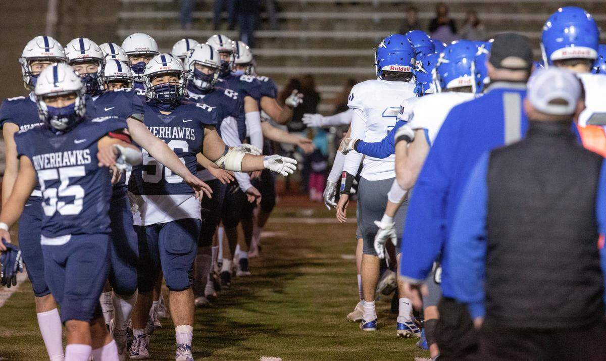 Football players from Chiawana and Walla Walla maintain social distancing guidelines by giving air handshakes after a game in Edgar Brown Memorial Stadium on Friday, March 19. The Riverhawks beat the Blue Devils 35-7.