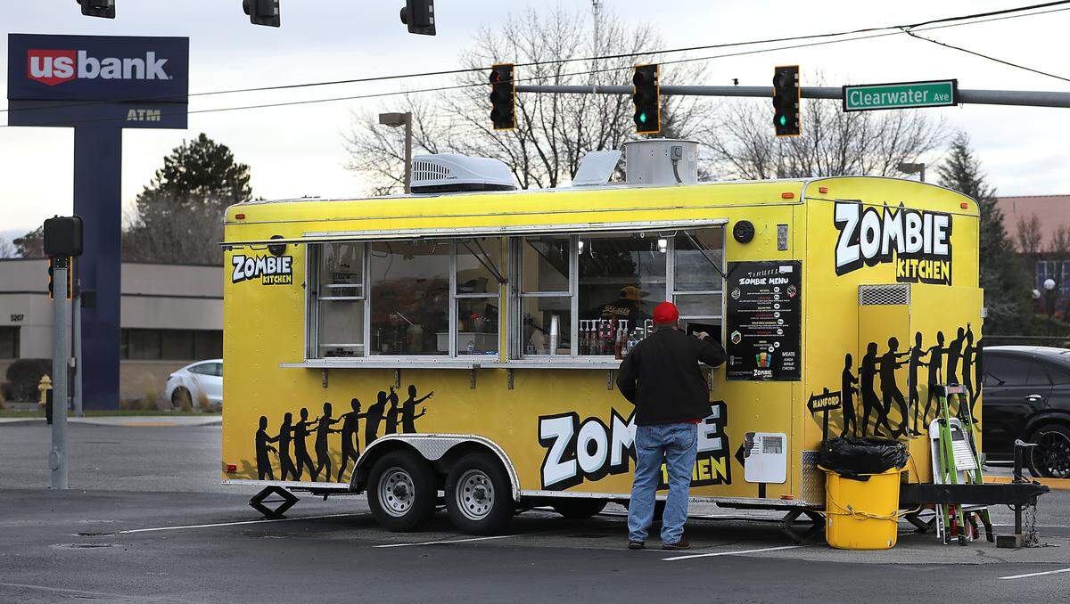 A customer places an order at the Zombie Kitchen mobile food trailer at its winter location front of Super Supplements at 5200 W. Clearwater Ave. in Kennewick. Jose and Yazmin Jimenez and their sister-in-law, Yazira, launched the business Jan. 8. The team spent about two years rehabilitating the former El Fat Cat Grill food truck into an event-focused mobile food kitchen.