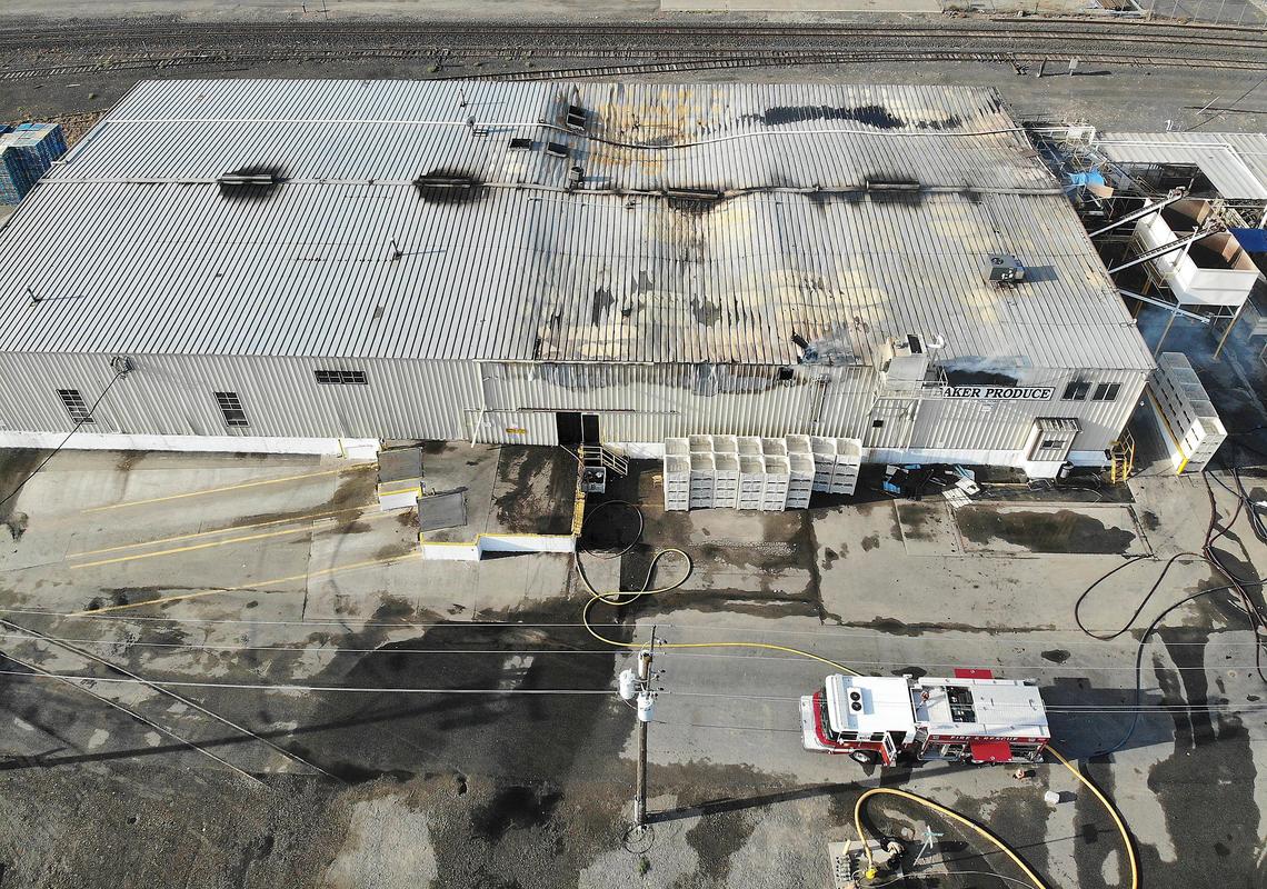 A Kennewick fire truck remains stationed on the scene of an overnight fire Wednesday at Baker Produce on Railroad Avenue in Kennewick. About half of the roof of the metal building is sagging from the heat and damage. Watch a video: tricityherald.com/video