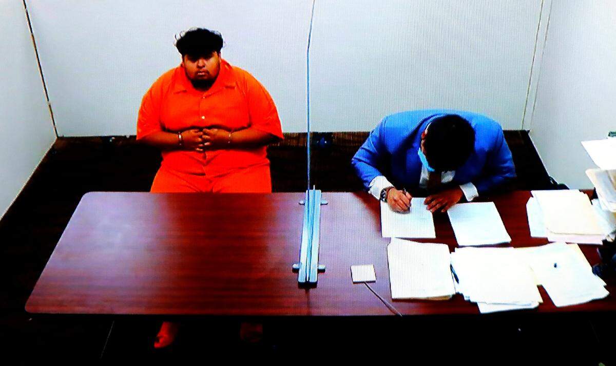 Murder suspect Brian Armando Panduro-Valenzuela sits near a provisional public defense lawyer Monday during his preliminary hearing using a video link from jail in Franklin County Superior Court in Pasco.