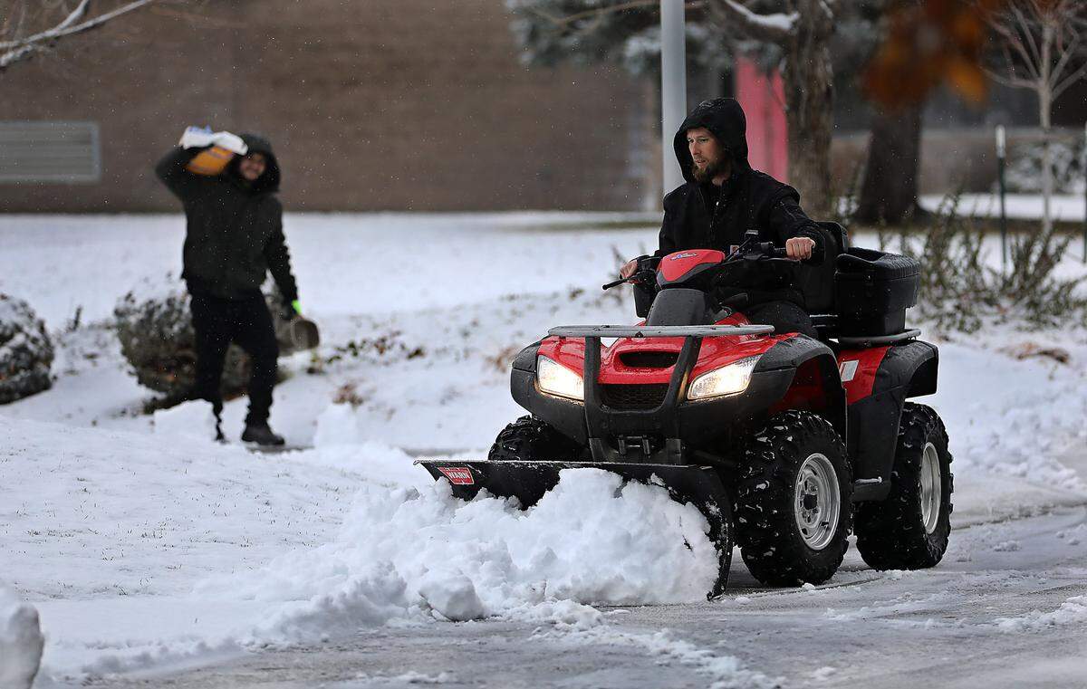 A pair of employees at the campus of the Toyota Center and Three Rivers Convention Center team up to clear snow and spread ice melt on the walkways at the facility in Kennewick. An early morning snowfall coated the ground, sidewalks and roadways around the Mid-Columbia.
