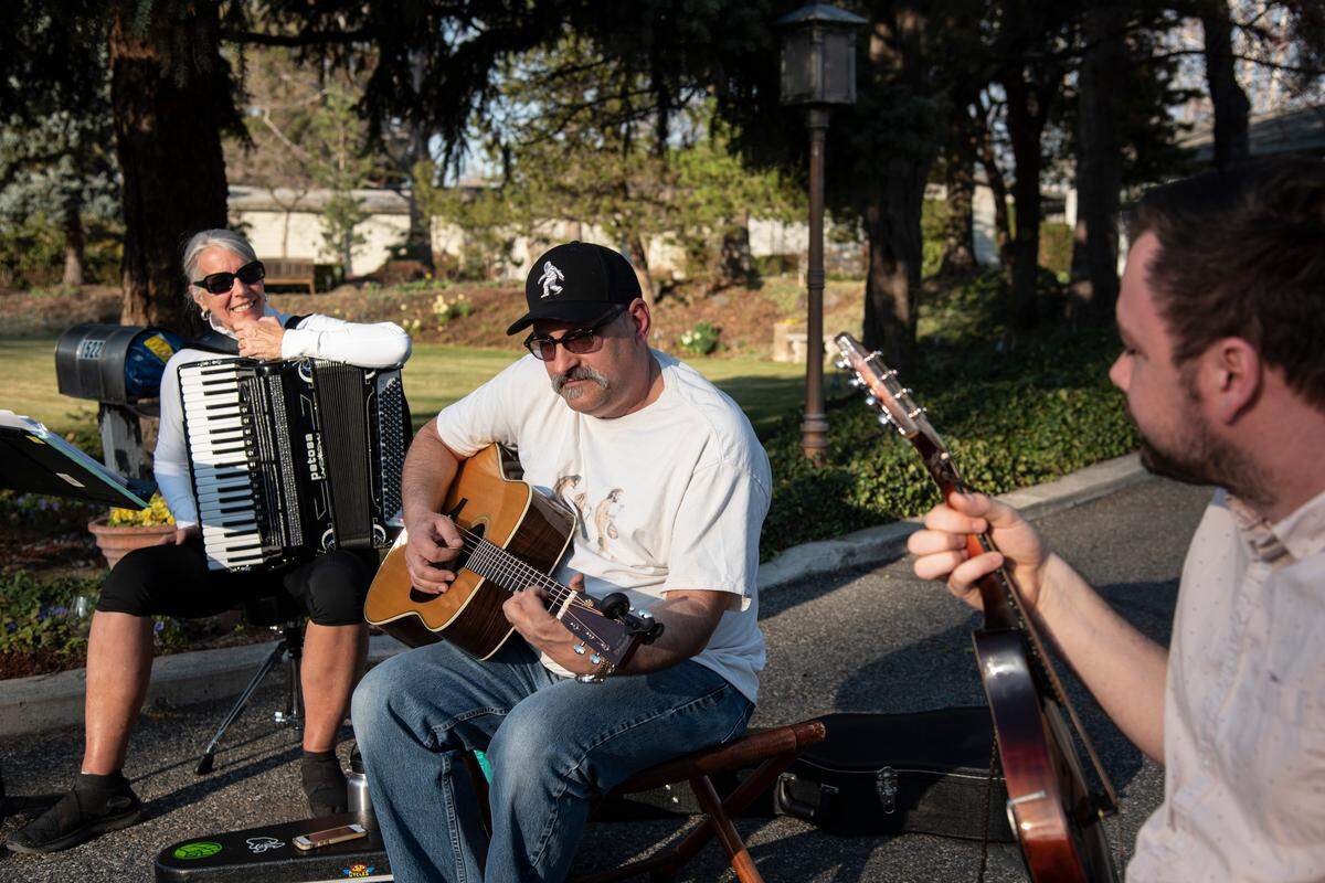 From left to right, neighbors Pat Holten, John Bartholomew and Zack McGuire have an impromptu evening jam session at the end of Holten’s driveway as a way to spread a little joy through music. Holten says that the need for connection, especially at a time like this, is one reason they decided to do it. “People will stop and say, ‘Hi,’” Holten said. “It makes it happy.”
