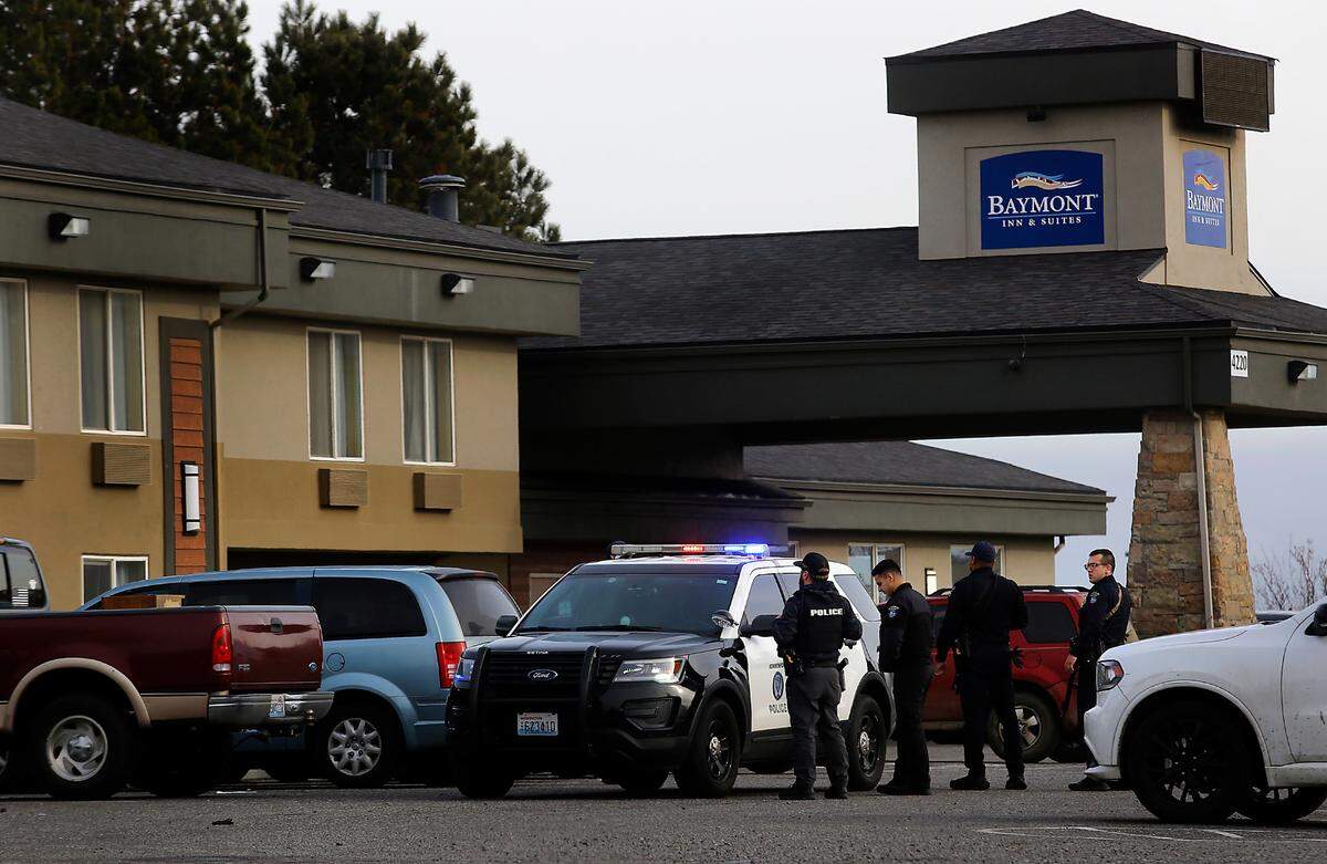 Kennewick police officers surround the Baymont Inn & Suites on West 27th Place in Kennewick in connection with a series of residential burglaries in the Tri-Cities region.