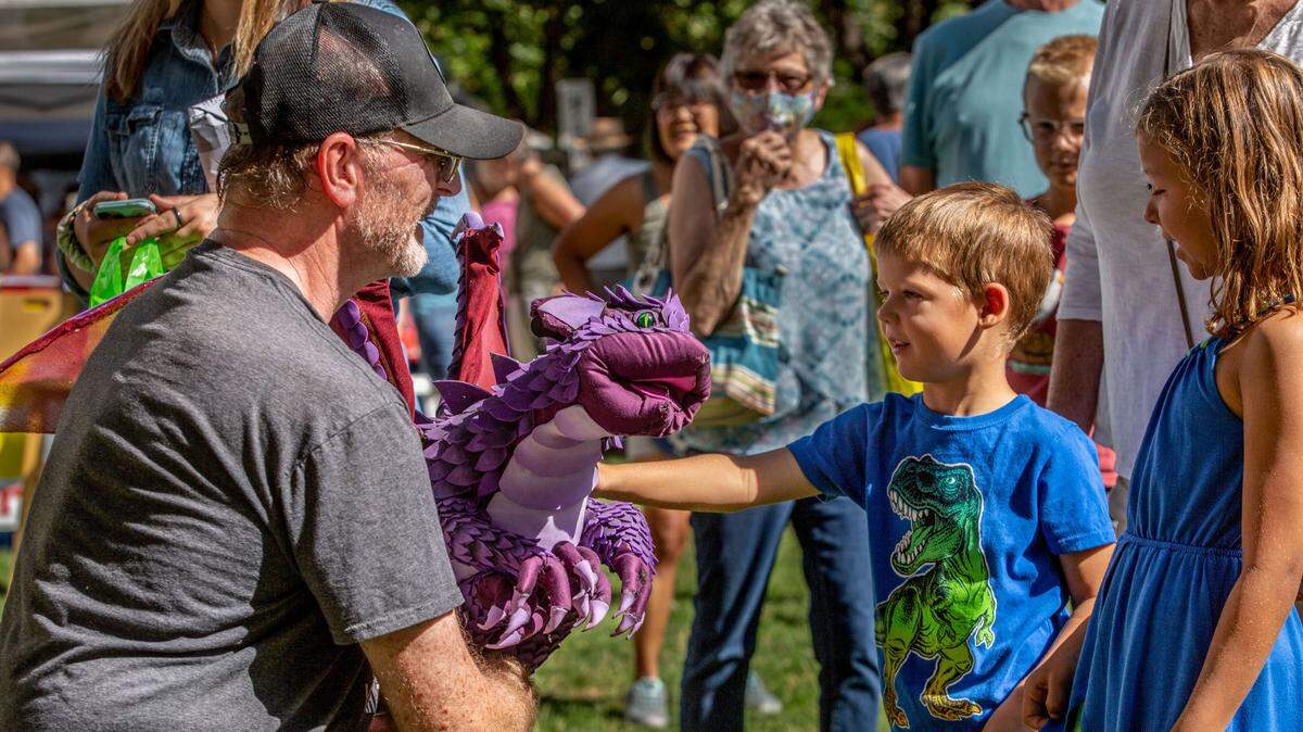 Beau Manley, 4, of West Richland, pets Henry, a purple dragon created by artist Herb Leonhard of Prosser during the first day of the 70th annual Art in the Park event at Howard Amon Park in Richland. The event, which runs Friday and Saturday, features over 300 local and national artists, as well as food vendors and entertainers. Leonhard’s illustrative work is featured in a number of children’s books, coloring books and in large murals at Adventures Underground in the Uptown in Richland.