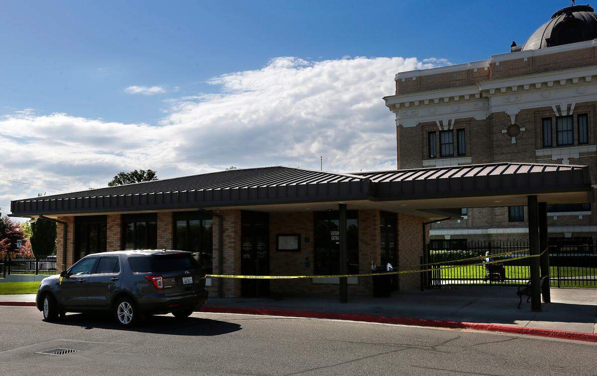 Crime scene tape and a law enforcement vehicle blocks the area to the security building at the Franklin County Courthouse early Monday in Pasco after blood were discovered on the sidewalk and entryway.