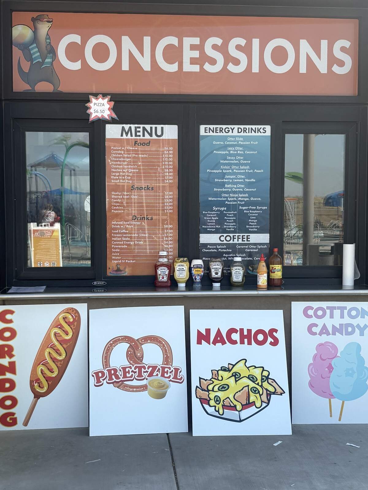 The concessions stand menu at the Pasco Aquatic Center includes meals like burgers and pizza, snacks like chips and popcorn, and an extensive drink menu with energy drink concoctions and coffees.