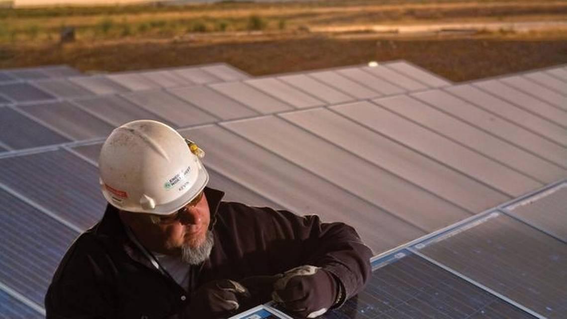 An Energy Northwest plant technician examines a solar panel at White Bluffs Solar Station, north of Richland. Construction has started to build a much larger Energy Northwest solar station with battery storage and a technician training center near Richland.