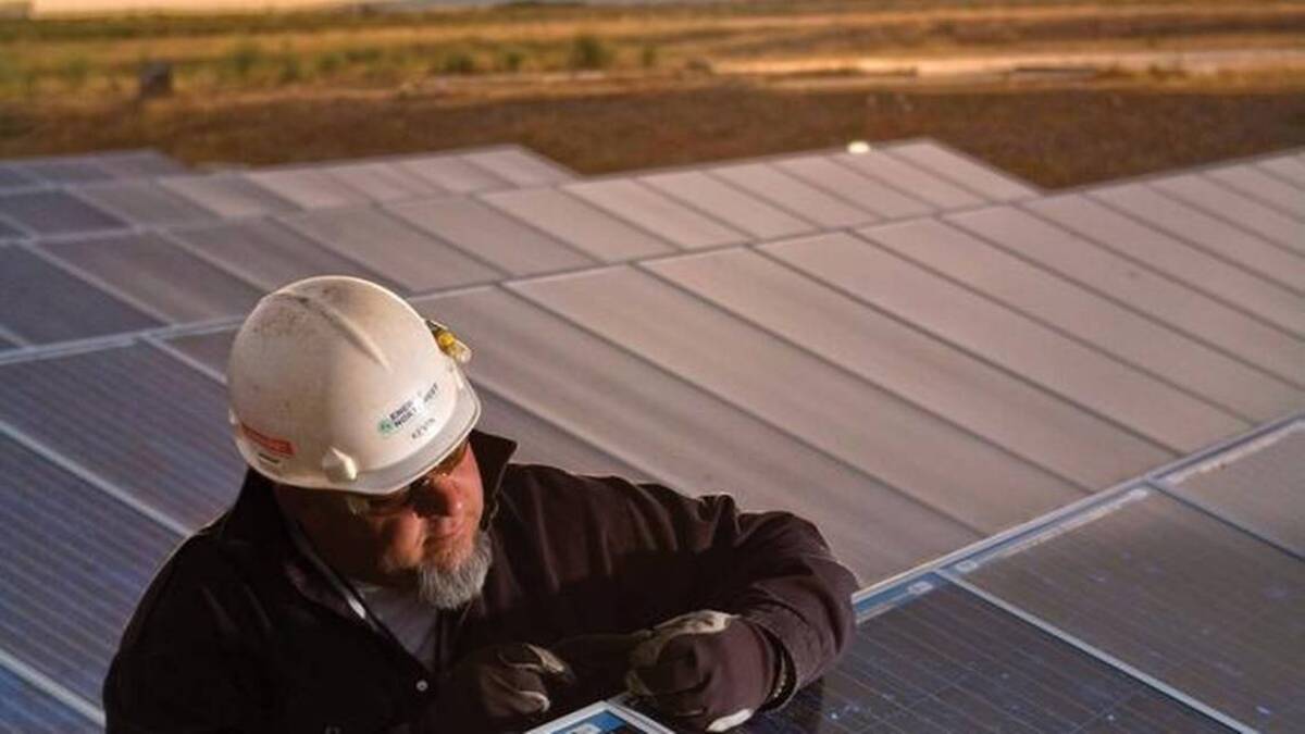 An Energy Northwest plant technician examines a solar panel at White Bluffs Solar Station, north of Richland. Construction has started to build a much larger Energy Northwest solar station with battery storage and a technician training center near Richland.