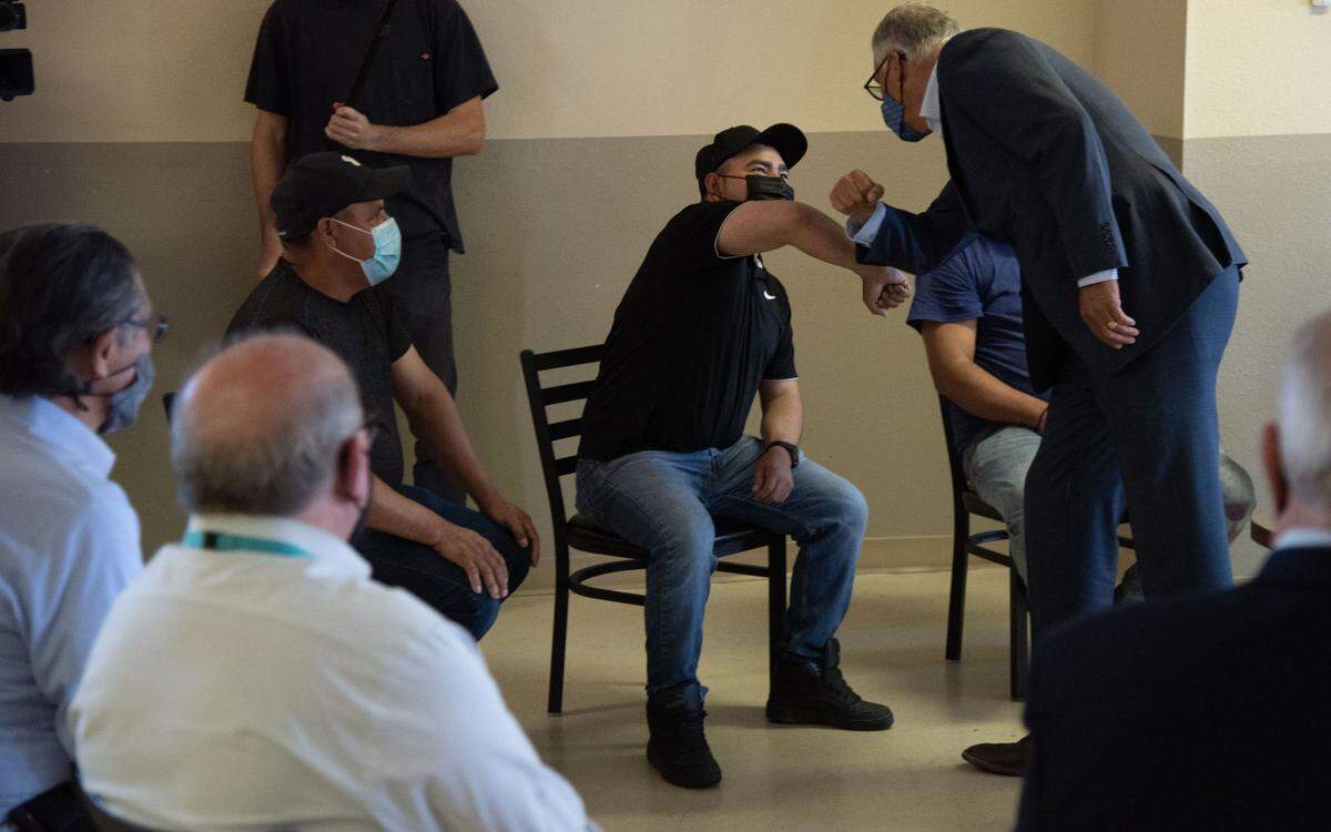 Gov. Jay Inslee greets farmworkers during a visit to Sea Mar La Posada East in Pasco. He spoke with workers, farmers and community leaders about how to get more people vaccinated and what to do about worker conditions and labor shortages.