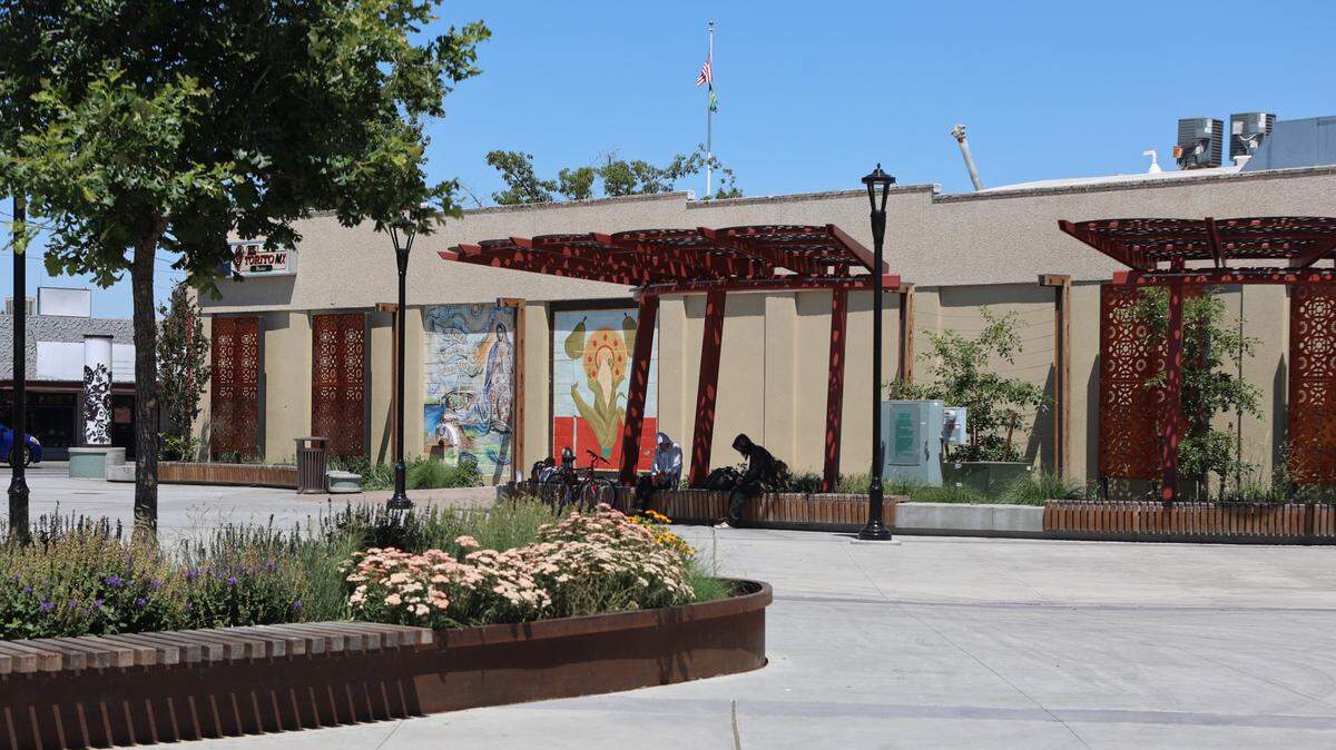 A small group of people sit in Peanuts Park in Pasco