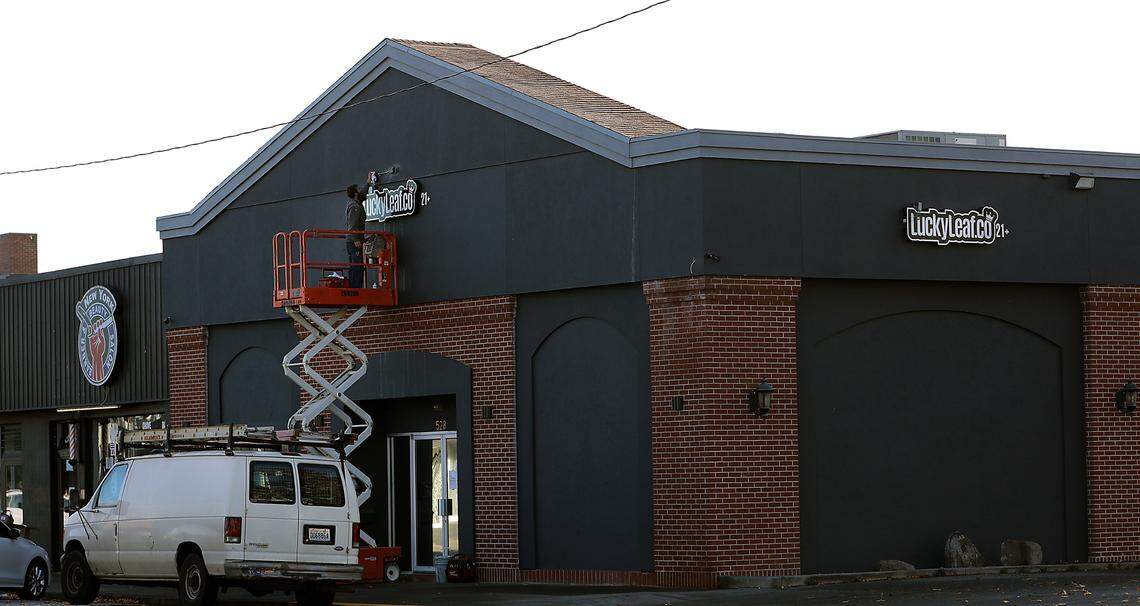 Electrician Clayton Purser works on the final steps of installing new signs at the Lucky Leaf cannabis store on Clark Street.