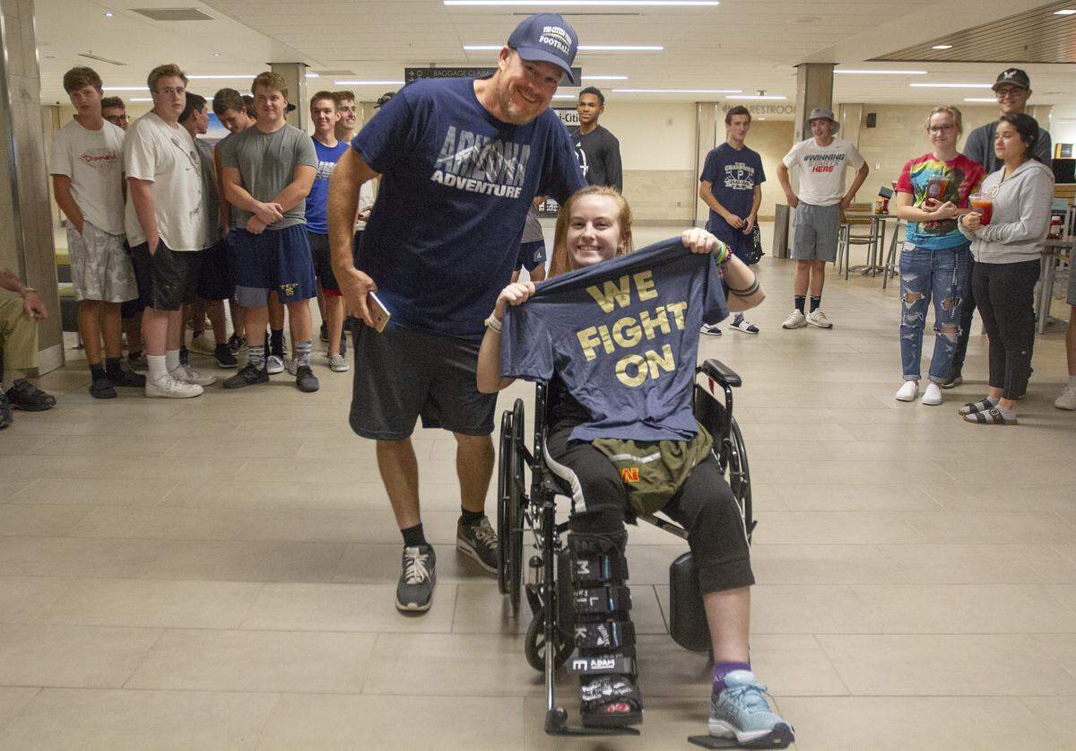Dan Whitsett, left, and Danika Whitsett pose for a photo holding a Tri-Cities Prep T-shirt at the Tri-Cities Airport in Pasco on Wednesday night.