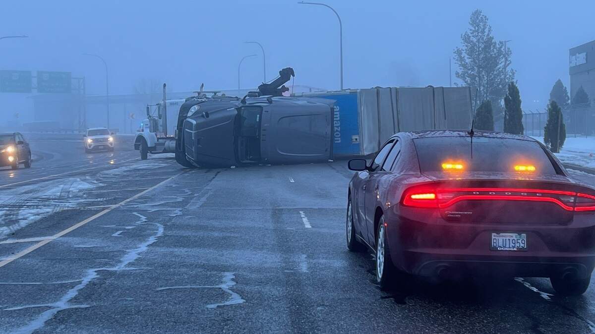 A semi truck hauling Amazon packages flipped in Pasco on icy Oregon Avenue (Highway 397) near the Interstate 182 interchange about 4:30 a.m. Monday.
