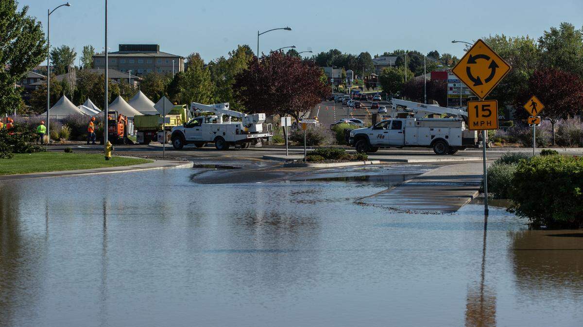 Crews work to drain water and unearth a 10-inch water main that water main that broke around 4 p.m. near the intersection of Center Parkway and Gage Boulevard in Kennewick.