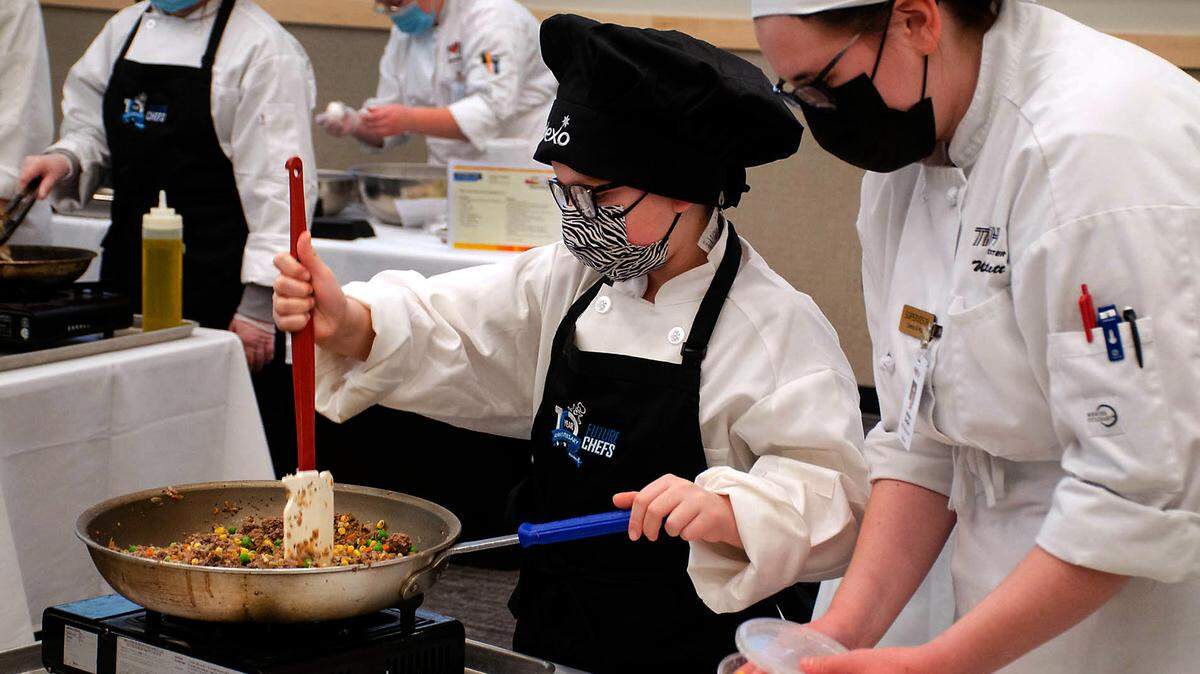 Elsie Fowler, a fourth grader from Southgate Elementary, sautes her Hogwarts shepherd’s pie while her supervisor, Whitley Bartlett, prepares ingredients during Friday’s Sodexo Future Chefs Challenge at the Tri-Tech Skils Center.