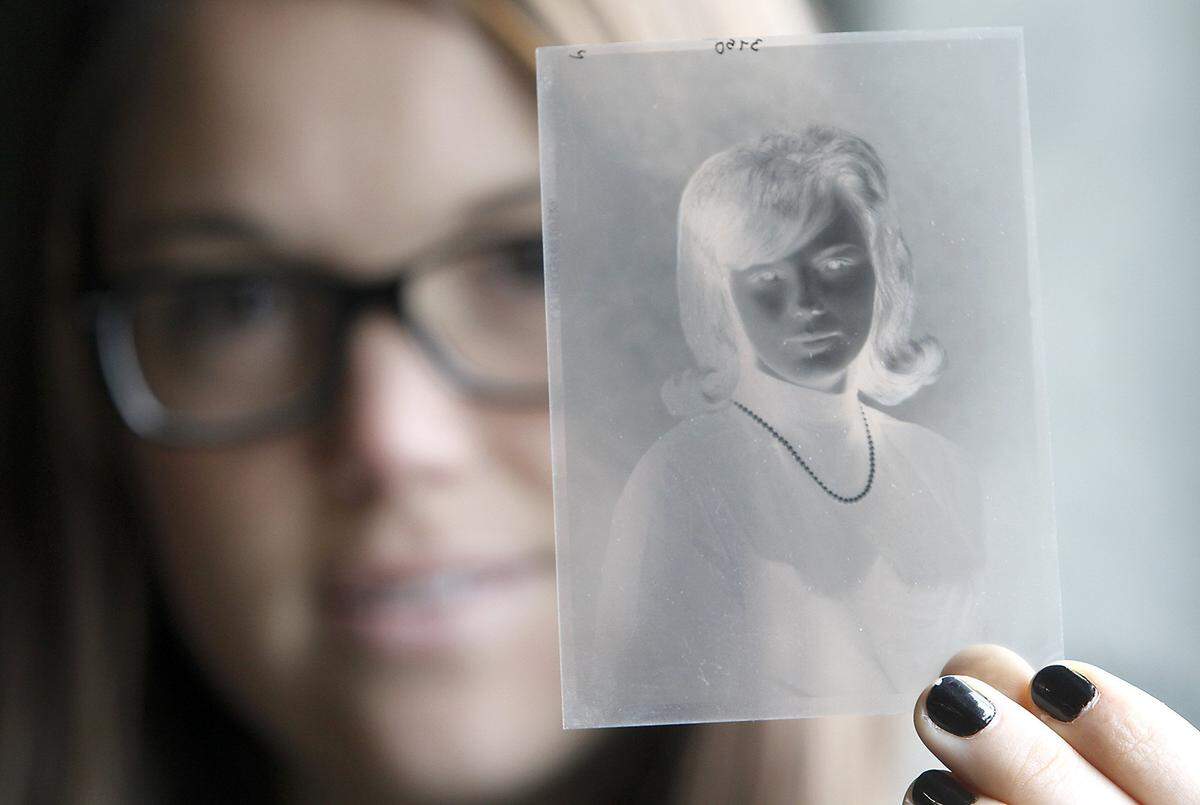 A Reach center employee in 2014 holds up a black and white negative from a local photographer taken for a senior high school portrait in 1964.