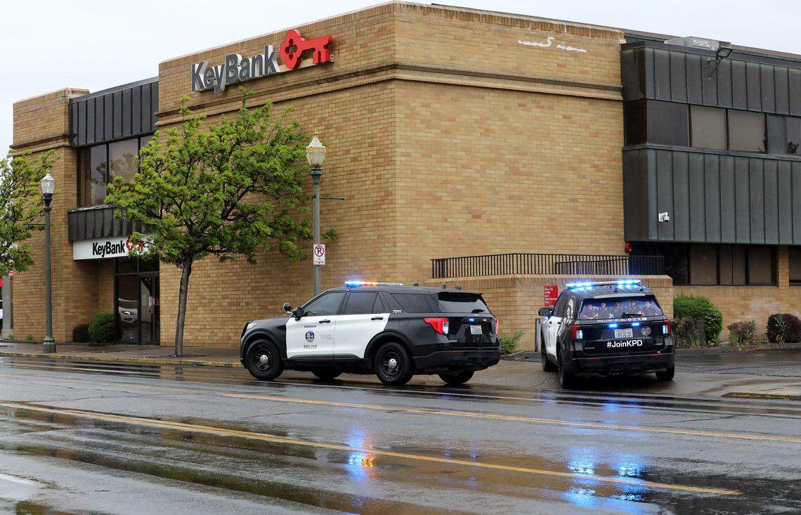  Kennewick Police patrol cars are positioned outside the Key Bank in downtown Kennewick Wednesday after responding to a robbery at the financial institution. The male suspect made it only about three blocks away before being arrested on South Auburn Street near West Third Avenue.